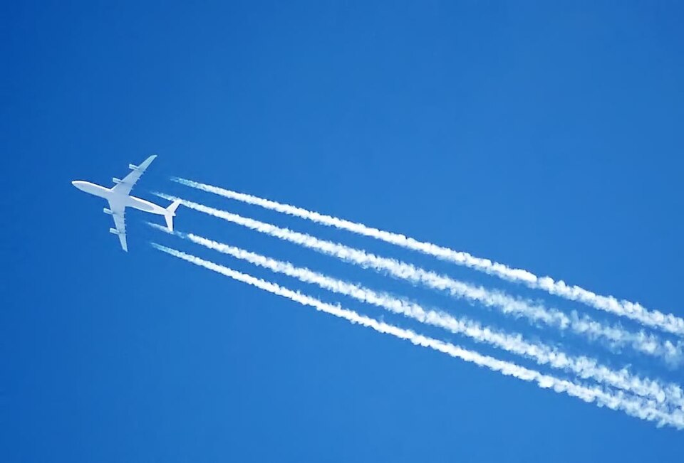 Aircraft contrails forming a grid pattern over a city