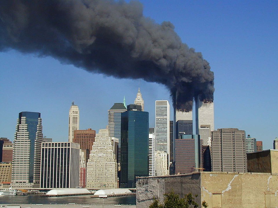 World Trade Center towers burning on September 11, 2001, with Statue of Liberty in foreground